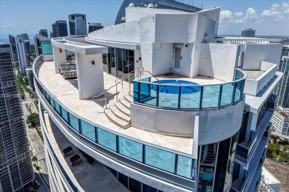 An aerial view of a high-rise balcony featuring a private circular pool and lounge area — 200 Biscayne Boulevard Way # 5401, Miami FL 33131, MIAMI, FL