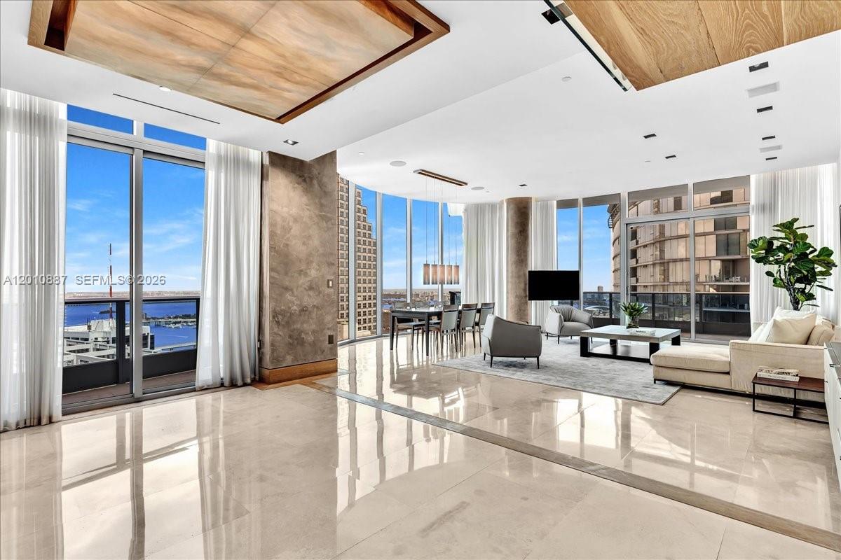 A spacious, modern living and dining area features floor-to-ceiling windows and polished marble floors — 200 Biscayne Boulevard Way # 5401, Miami FL 33131, MIAMI, FL