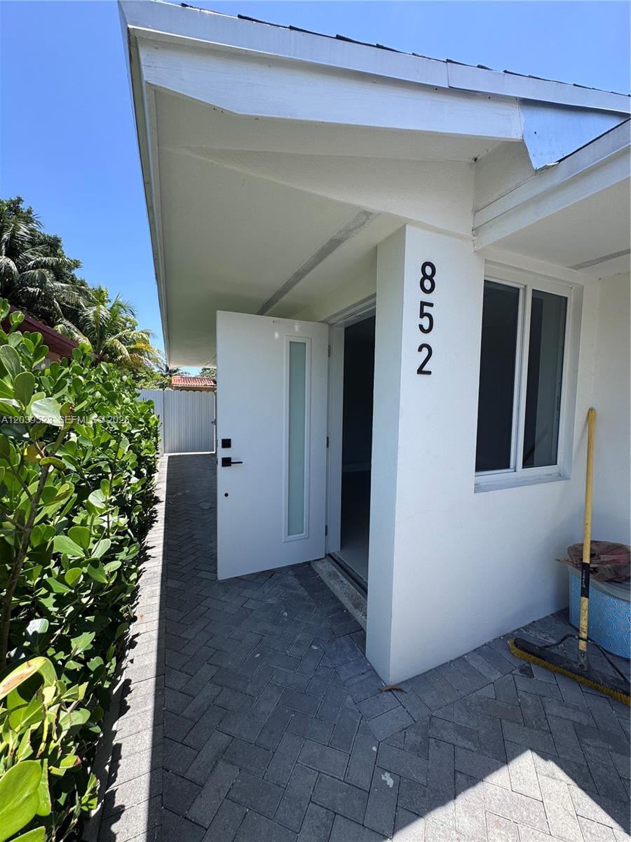 A white exterior wall features the house number 852 next to an open door — 850 NW 109th St # 852, Miami FL 33168, MIAMI, FL