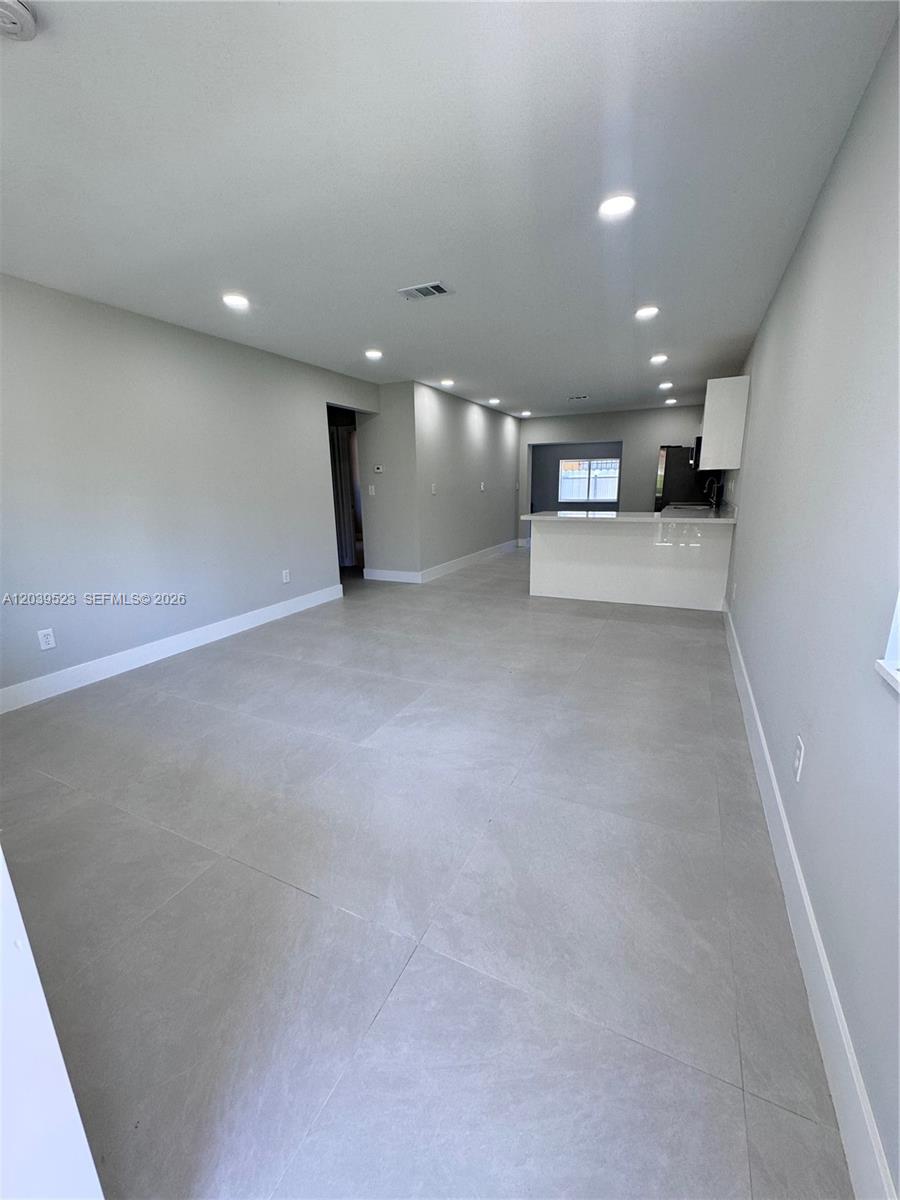 This open-concept living area features large gray floor tiles and recessed ceiling lighting — 850 NW 109th St # 852, Miami FL 33168, MIAMI, FL