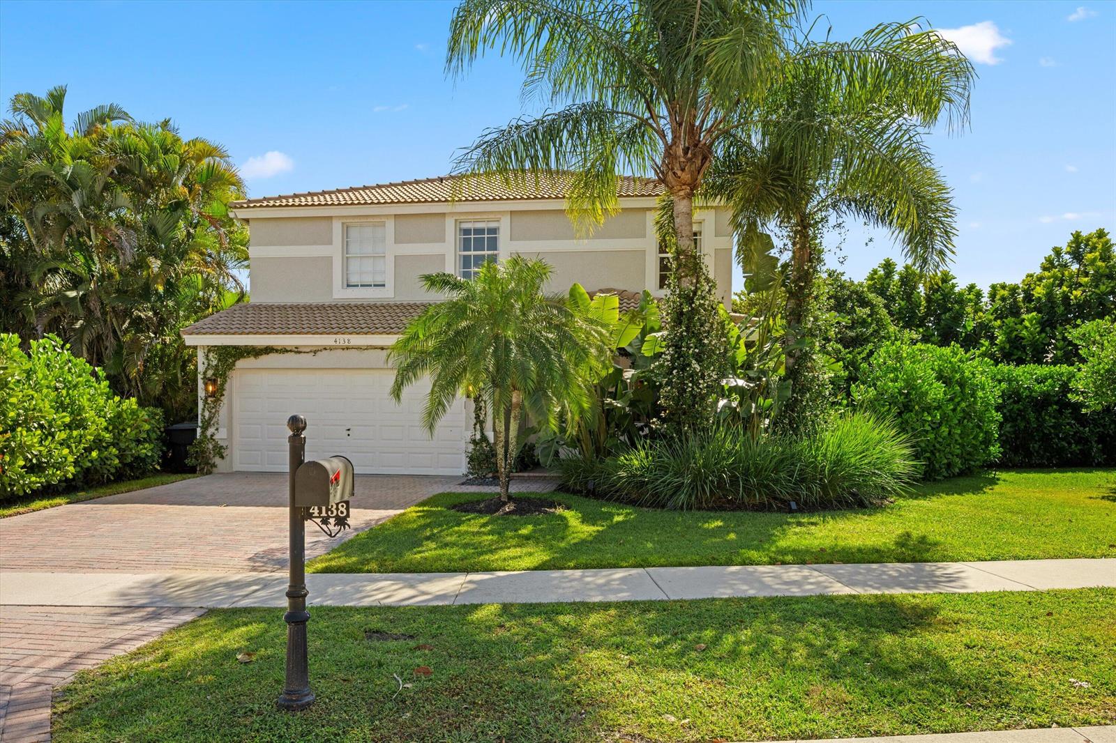 A two-story house with a beige exterior, a tiled roof, and a paved driveway — 4138 Bluff Harbor Way, Wellington FL 33449, WELLINGTON, FL