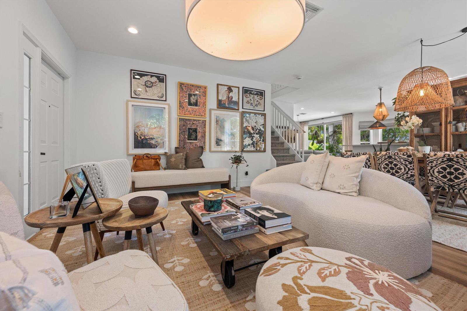 A living room features a curved sofa, a wooden coffee table, and a gallery wall — 4138 Bluff Harbor Way, Wellington FL 33449, WELLINGTON, FL