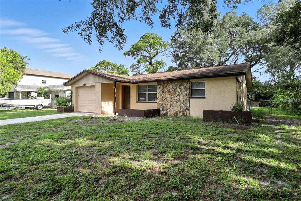 A single-story house with a stone facade, a one-car garage, and a grassy front yard — 8035 GULF WAY, HUDSON, FL
