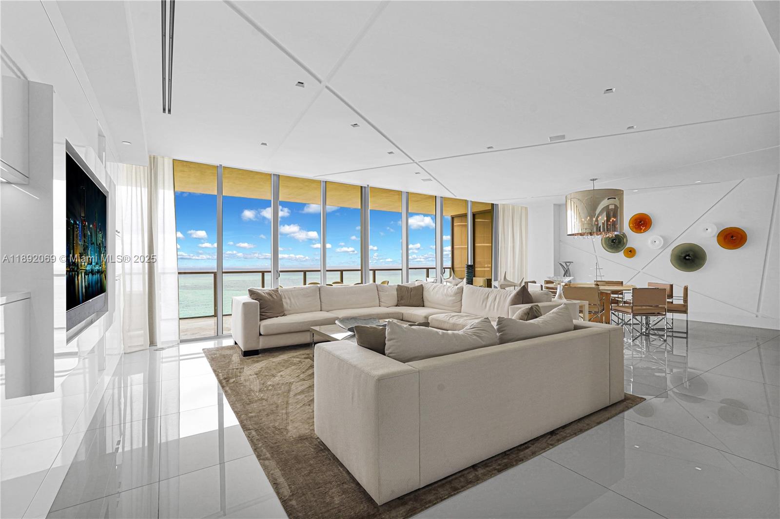 A modern living room features white tile floors, a large sectional sofa, and floor-to-ceiling windows — 9701 Collins Ave # 2103S, Bal Harbour FL 33154, BAL HARBOUR, FL