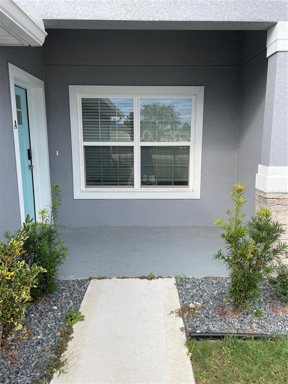 The exterior entryway features a light blue door, a large window, and a concrete walkway — 110 LYNBROOK DRIVE UNIT A, PALM COAST, FL