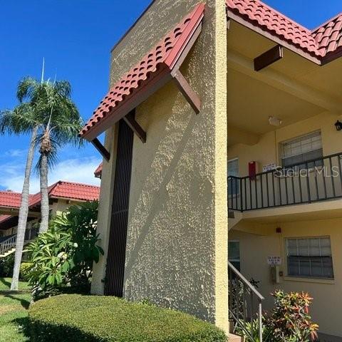 Exterior view of a multi-story apartment building with stucco walls and a red tile roof — 1845 S HIGHLAND AVENUE UNIT 15, LARGO, FL