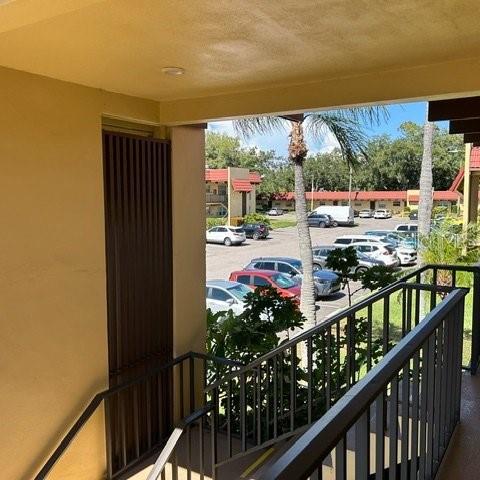 A view from a balcony overlooking a parking lot with several cars and apartment buildings — 1845 S HIGHLAND AVENUE UNIT 15, LARGO, FL