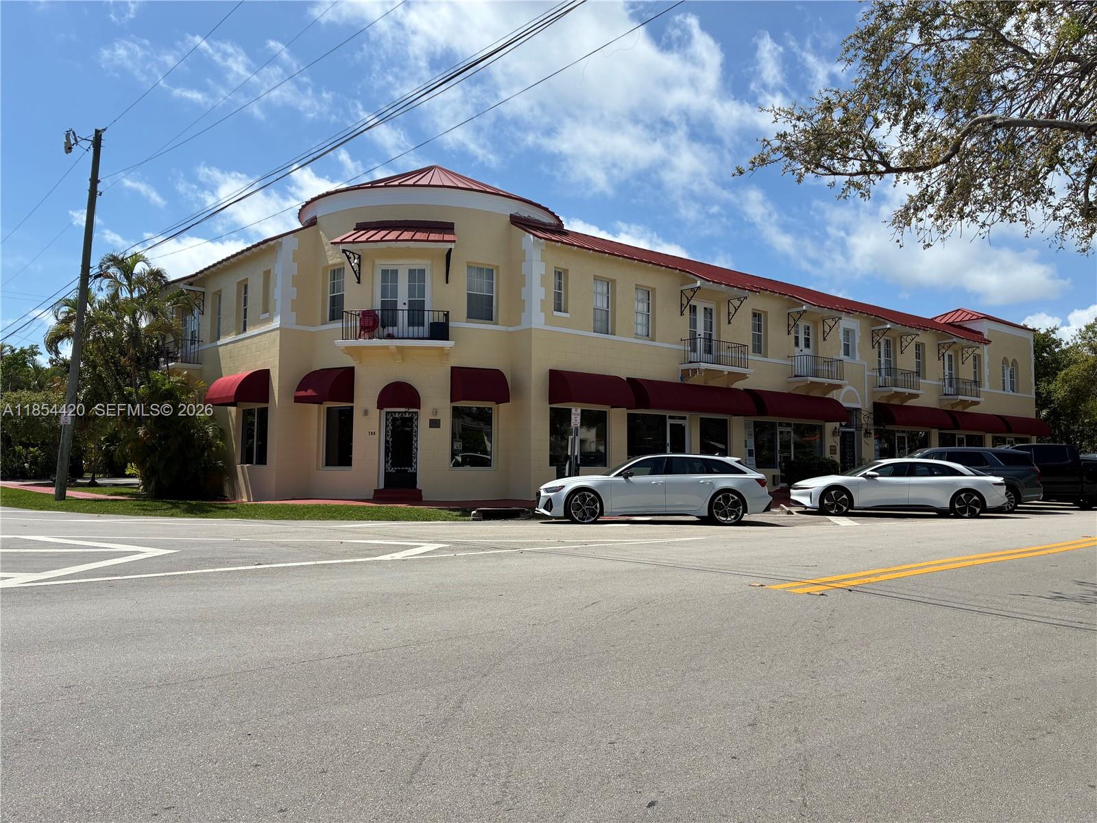 A two-story yellow commercial building with a red roof and red awnings sits on a corner — 710 W 51st St, Miami Beach FL 33140, MIAMI BEACH, FL