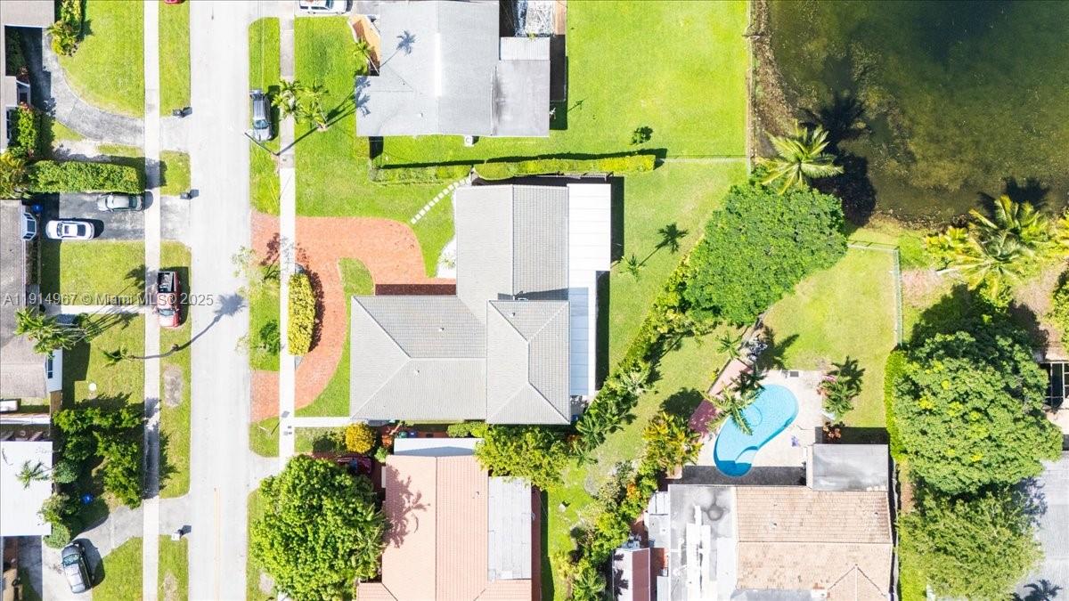 An aerial view shows a house with a pool, a driveway, and surrounding landscaping — 1961 NE 188th St, Miami FL 33179, MIAMI, FL