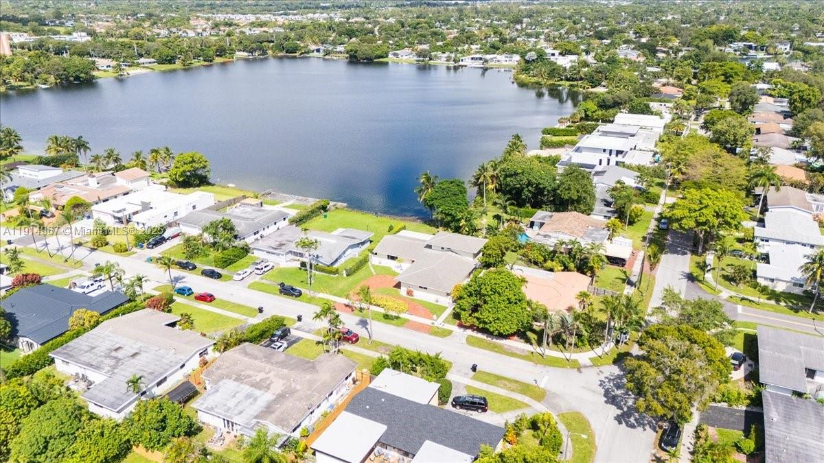 An aerial view shows a residential neighborhood situated along the shore of a large lake — 1961 NE 188th St, Miami FL 33179, MIAMI, FL