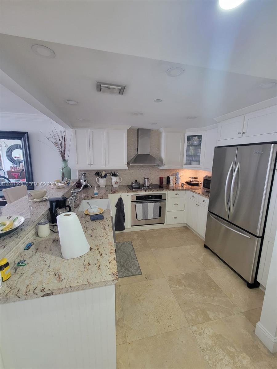 A kitchen features white cabinets, stainless steel appliances, and light-colored granite countertops — 2625 Collins Ave # 1601, Miami Beach FL 33140, MIAMI BEACH, FL