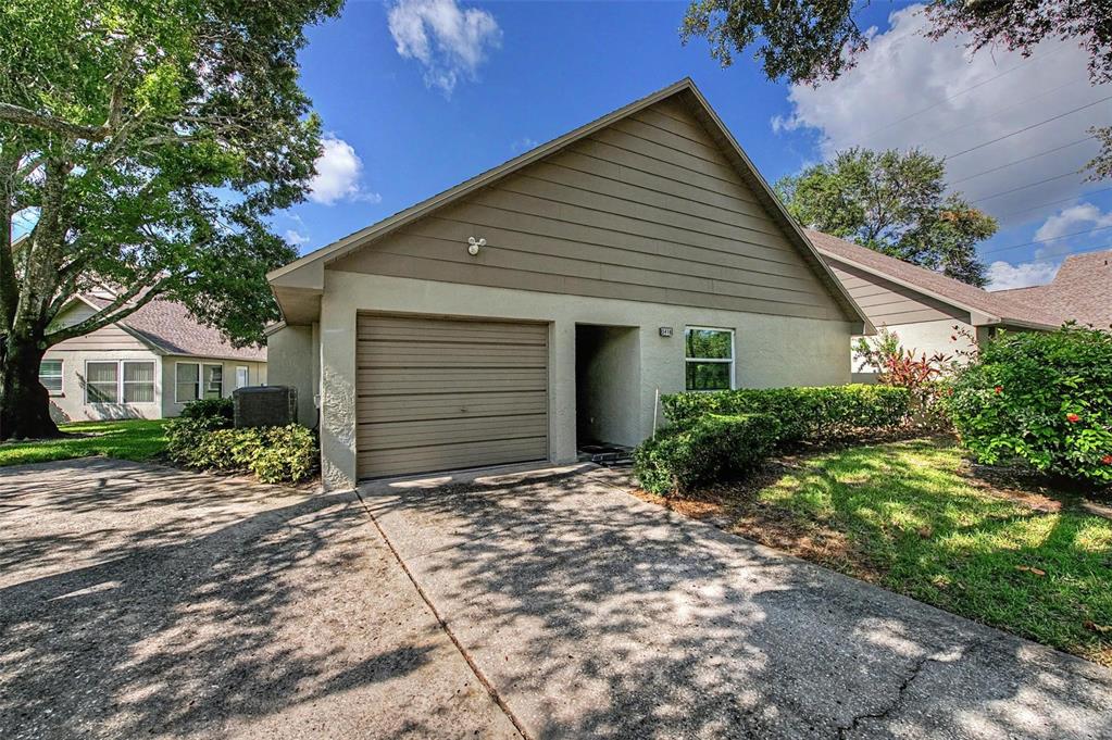A single-story house with a tan stucco exterior, a brown garage door, and a concrete driveway — 3419 ANNETTE COURT, CLEARWATER, FL