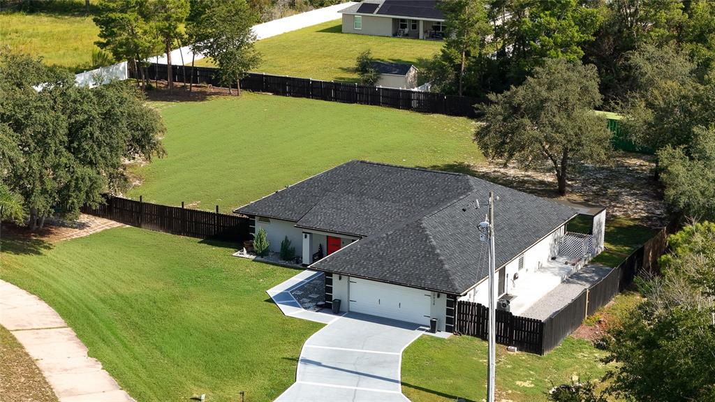 An aerial view of a single-story house with a dark roof and a fenced yard — 10924 SW 48TH TERRACE, OCALA, FL