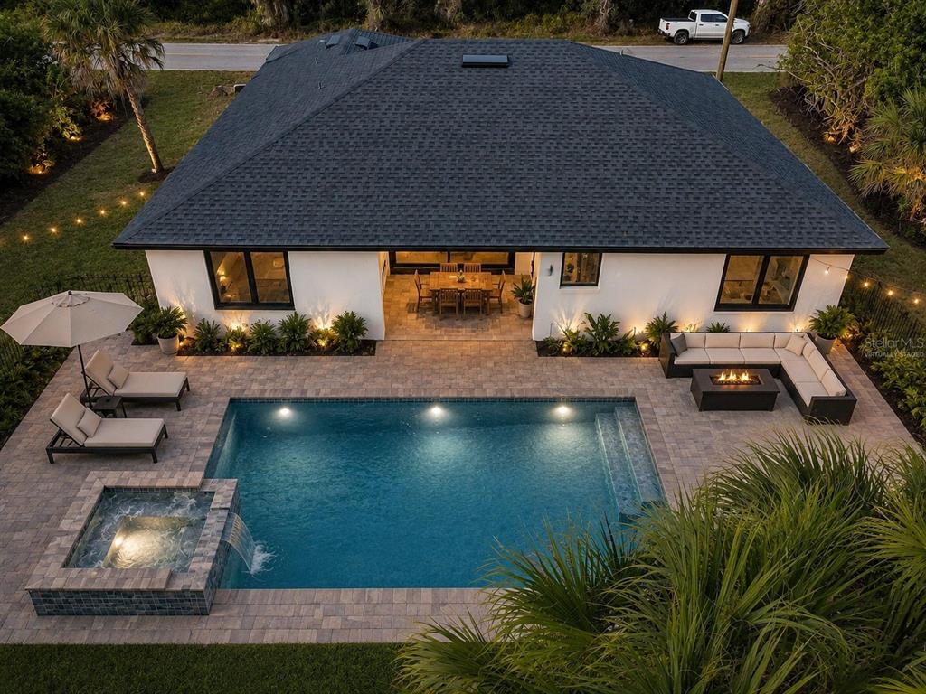 An aerial view of a house exterior featuring a swimming pool, spa, and patio furniture — 72 SHORELAND STREET, PORT CHARLOTTE, FL