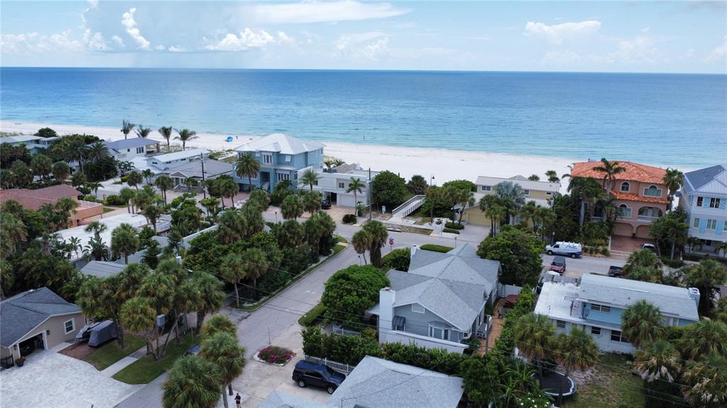 An aerial view of a coastal neighborhood with houses, palm trees, and a sandy beach — 850 MANDALAY AVENUE, CLEARWATER BEACH, FL