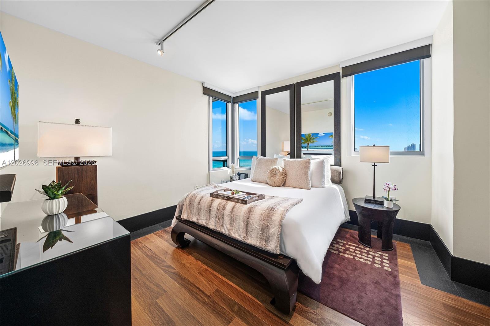 A bedroom with wood floors, a platform bed, and windows overlooking the ocean — 101 20th St # 2404, Miami Beach FL 33139, MIAMI BEACH, FL