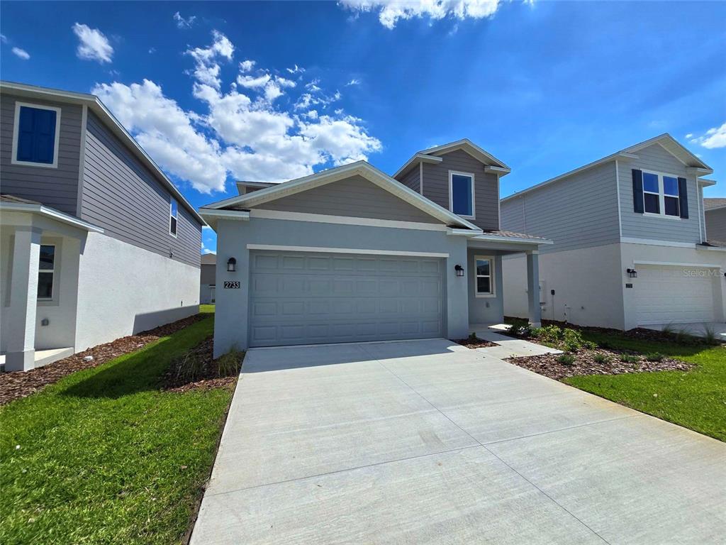 A two-story house with a gray garage, light blue siding, and a concrete driveway — 2733 LOOKOUT RIDGE ROAD, HAINES CITY, FL