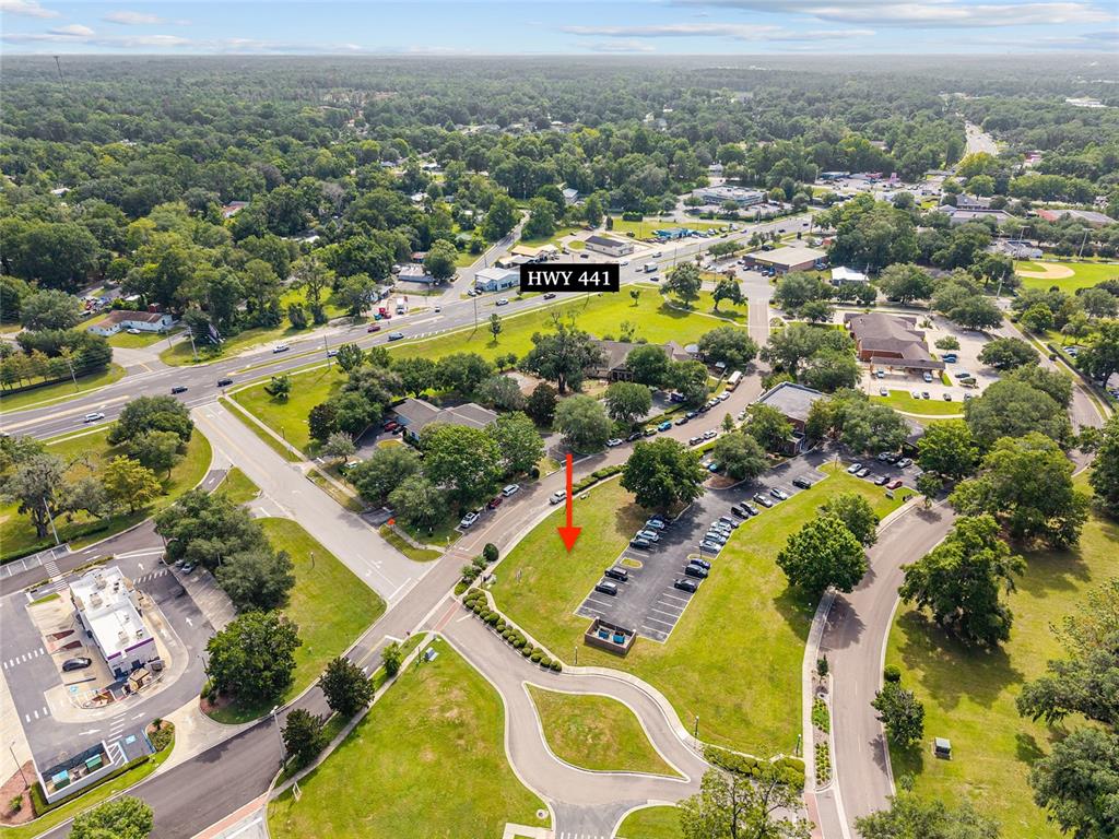 An aerial view shows a vacant grassy lot adjacent to a parking area and road — 14485 NW 152ND LANE, ALACHUA, FL