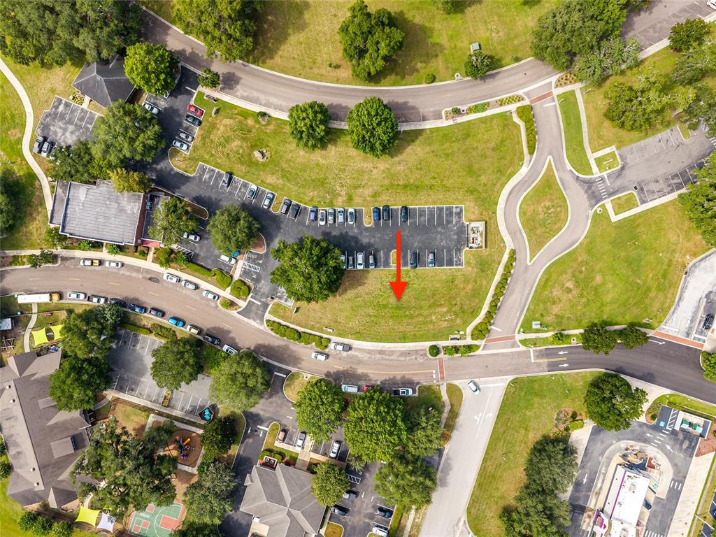 This aerial view shows a parking lot and a grassy plot marked by an arrow — 14485 NW 152ND LANE, ALACHUA, FL