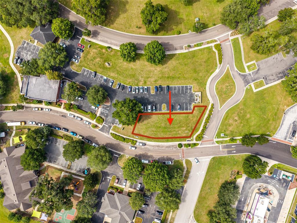 This aerial view shows a vacant, grass-covered lot outlined in red within a commercial area — 14485 NW 152ND LANE, ALACHUA, FL