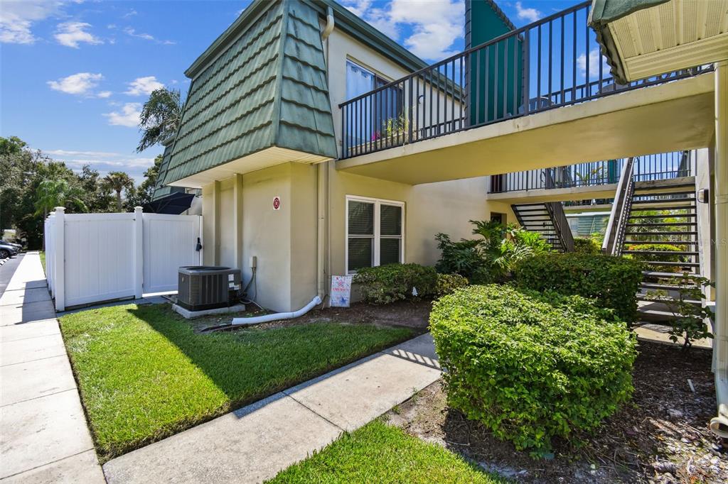 A two-story apartment building exterior features a green mansard roof, a balcony, and stairs — 1799 N HIGHLAND AVENUE UNIT 169, CLEARWATER, FL