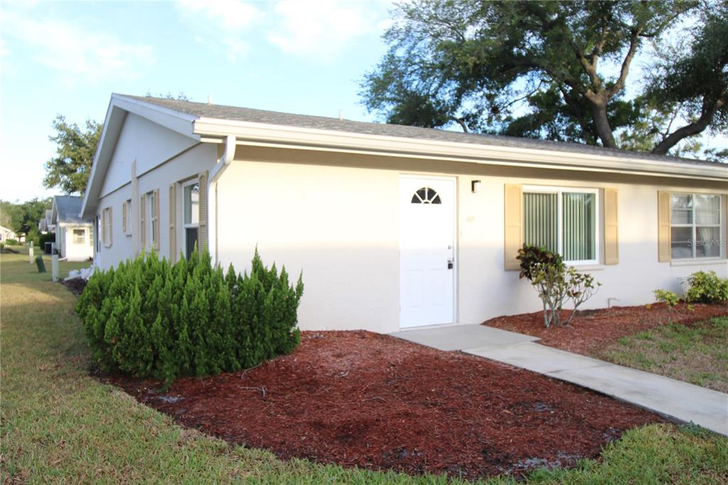 A single-story house with a white exterior, a front door, and a concrete walkway — 2202 CLUBHOUSE DRIVE UNIT 185, SUN CITY CENTER, FL