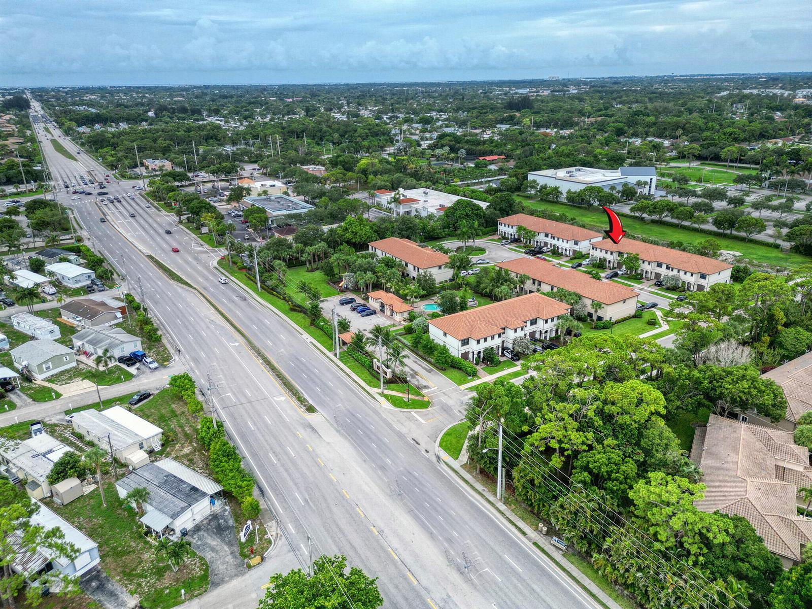 A backyard patio features a blue umbrella, a portable grill, and a wooden privacy fence — 4656 Silver Saw Lane, Lake Worth FL 33463, LAKE WORTH, FL