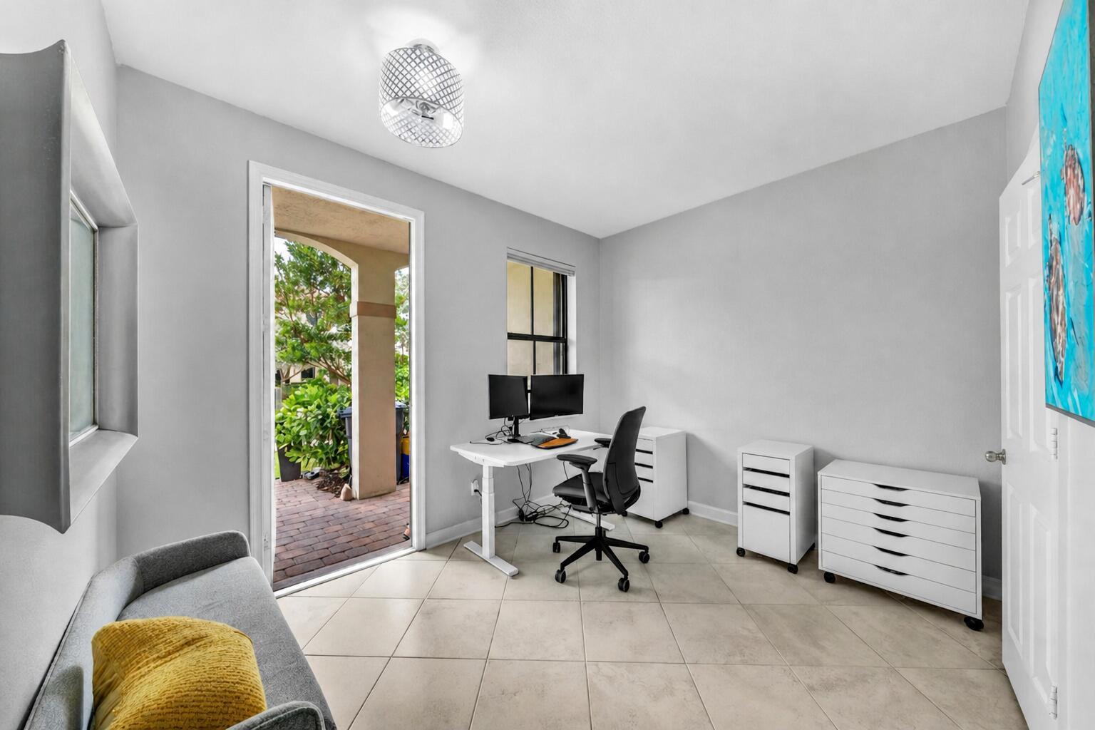 A hallway with tile floors leads past a bathroom and console table toward a living area — 4656 Silver Saw Lane, Lake Worth FL 33463, LAKE WORTH, FL