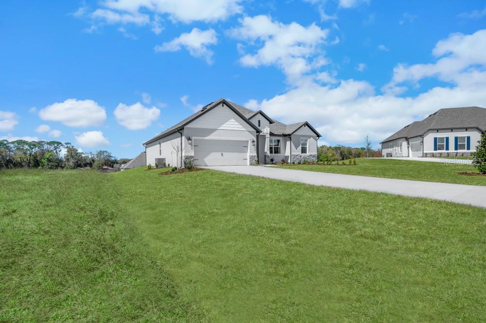 A single-story house with a white exterior, stone accents, and a two-car garage — 3849 SADDLE HILL TRAIL, FRUITLAND PARK, FL