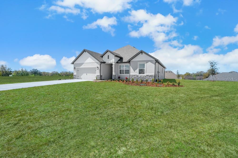 A single-story house with a white exterior, stone accents, and a two-car garage — 3849 SADDLE HILL TRAIL, FRUITLAND PARK, FL