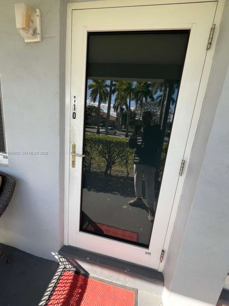 A white storm door with a glass panel and the number 110 is installed — 600 Layne Blvd # 110, Hallandale Beach FL 33009, HALLANDALE BEACH, FL