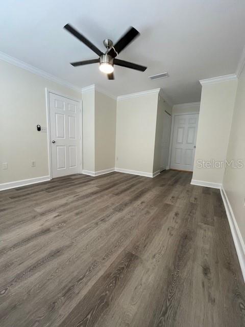 An empty room features light-colored walls, a ceiling fan, and wood-look flooring — 18319 BRIDLE CLUB DRIVE, TAMPA, FL