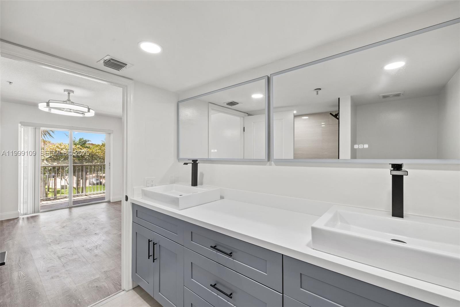 A bathroom features a gray double vanity with white vessel sinks and a balcony view — 470 S Park Rd # 307, Hollywood FL 33021, HOLLYWOOD, FL