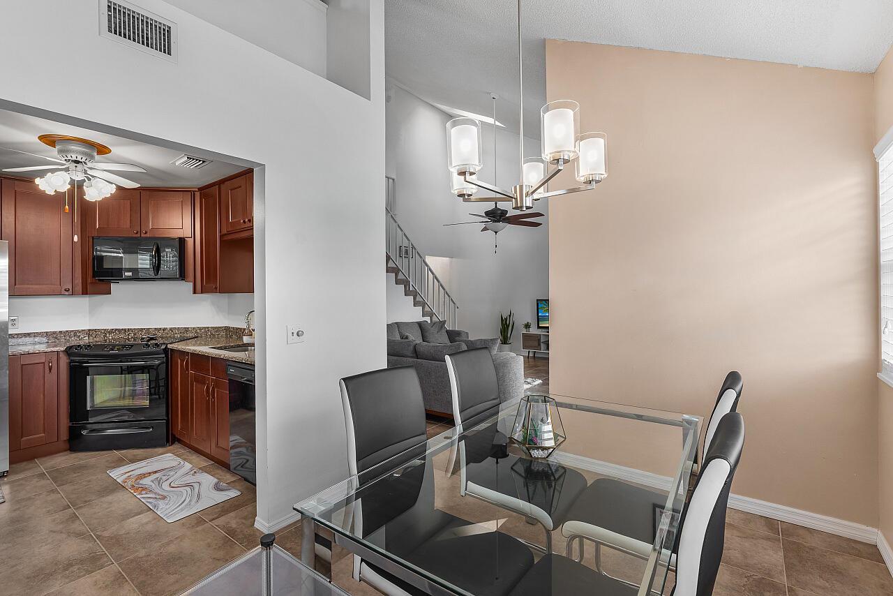 A dining area with a glass table and chairs opens into a kitchen and living room — 1965 Westminster Circle # 6, Vero Beach FL 32966, VERO BEACH, FL