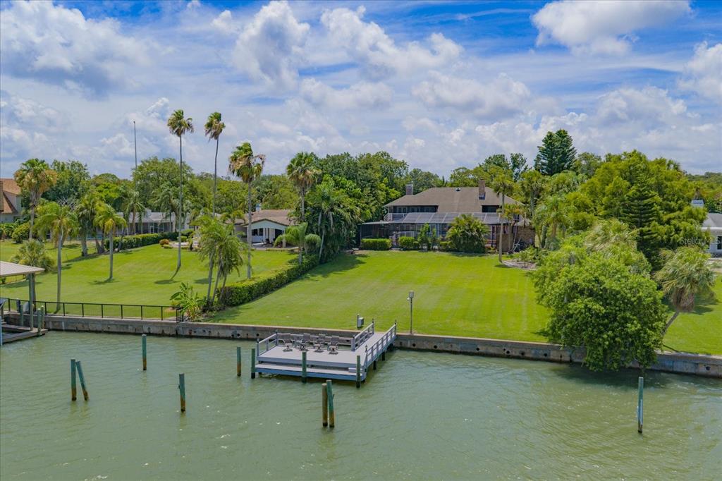 An aerial view shows a large waterfront property with a grassy lawn and private dock — 220 HARBOR VIEW LANE, LARGO, FL