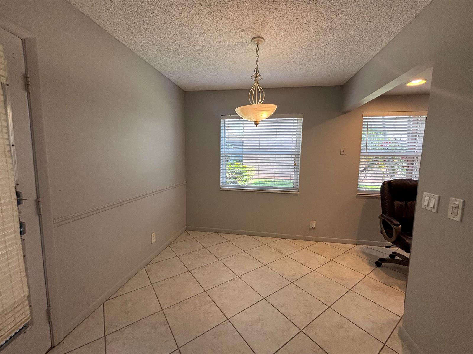 A dining area features light gray walls, tile flooring, a pendant light, and two windows — 341 Piedmont # H, Delray Beach FL 33484, DELRAY BEACH, FL