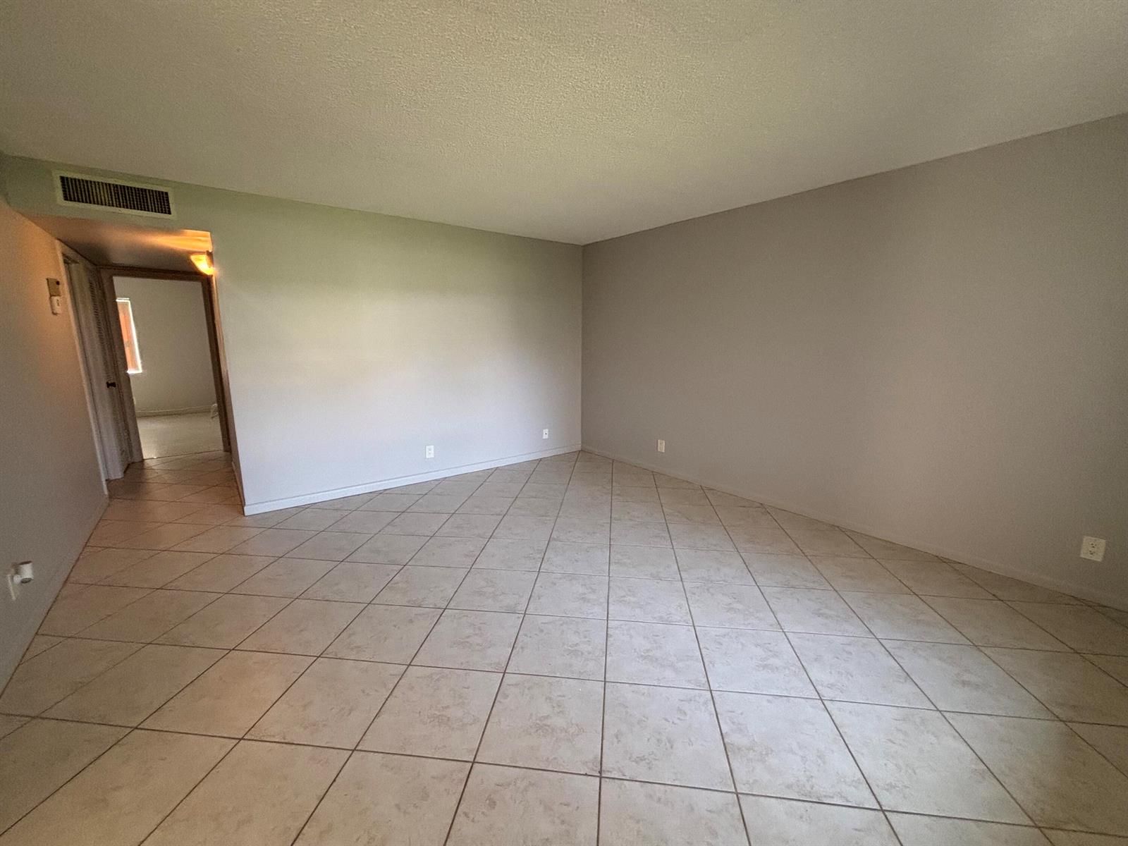An empty room with light-colored tile flooring and neutral gray walls — 341 Piedmont # H, Delray Beach FL 33484, DELRAY BEACH, FL