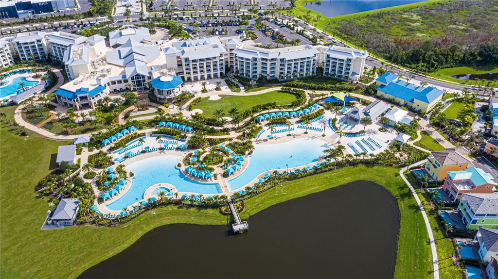 An aerial view of a resort complex featuring a large swimming pool and a lake — 2956 ON THE ROCKS, KISSIMMEE, FL
