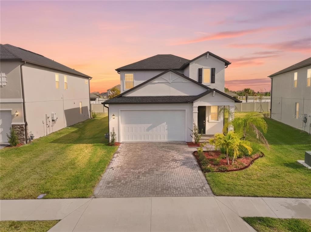 A two-story house with a white stucco exterior, a paved driveway, and a landscaped front yard — 11534 72ND PLACE E, PALMETTO, FL