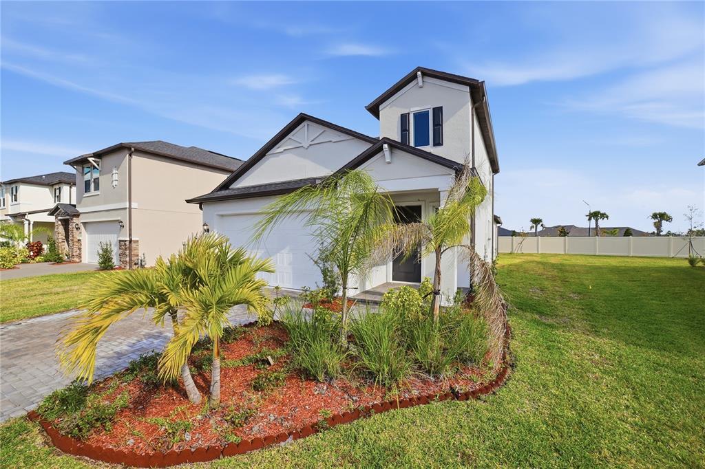A two-story house with a white stucco facade, dark roof, and a paved driveway — 11534 72ND PLACE E, PALMETTO, FL
