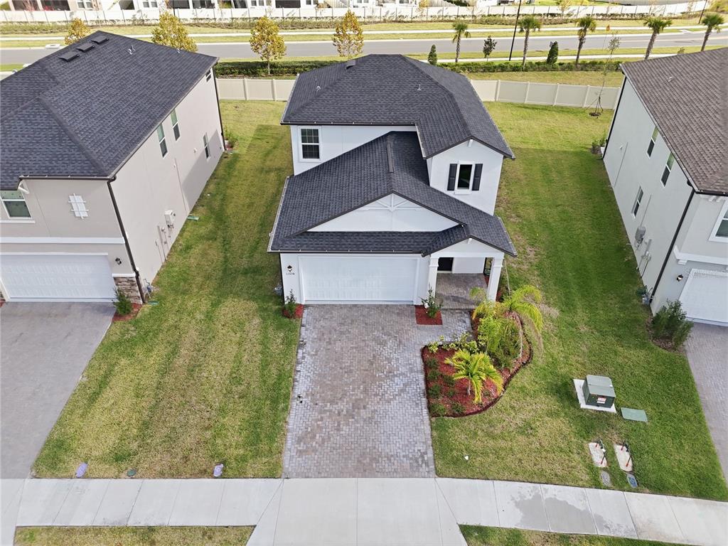 An aerial view shows a two-story house with a white exterior, dark roof, and paver driveway — 11534 72ND PLACE E, PALMETTO, FL