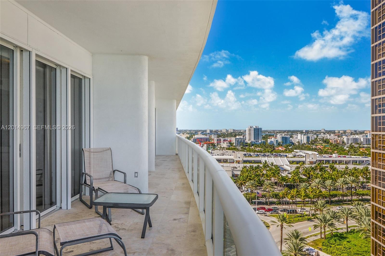 A high-rise balcony features tile flooring, outdoor furniture, and a view of the city — 9601 Collins Ave # 1502, Bal Harbour FL 33154, BAL HARBOUR, FL