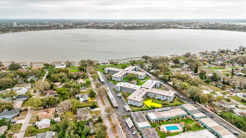 An aerial view shows apartment buildings near a large lake with a yellow arrow — 333 LAKE HOWARD DR NW UNIT 314D, WINTER HAVEN, FL