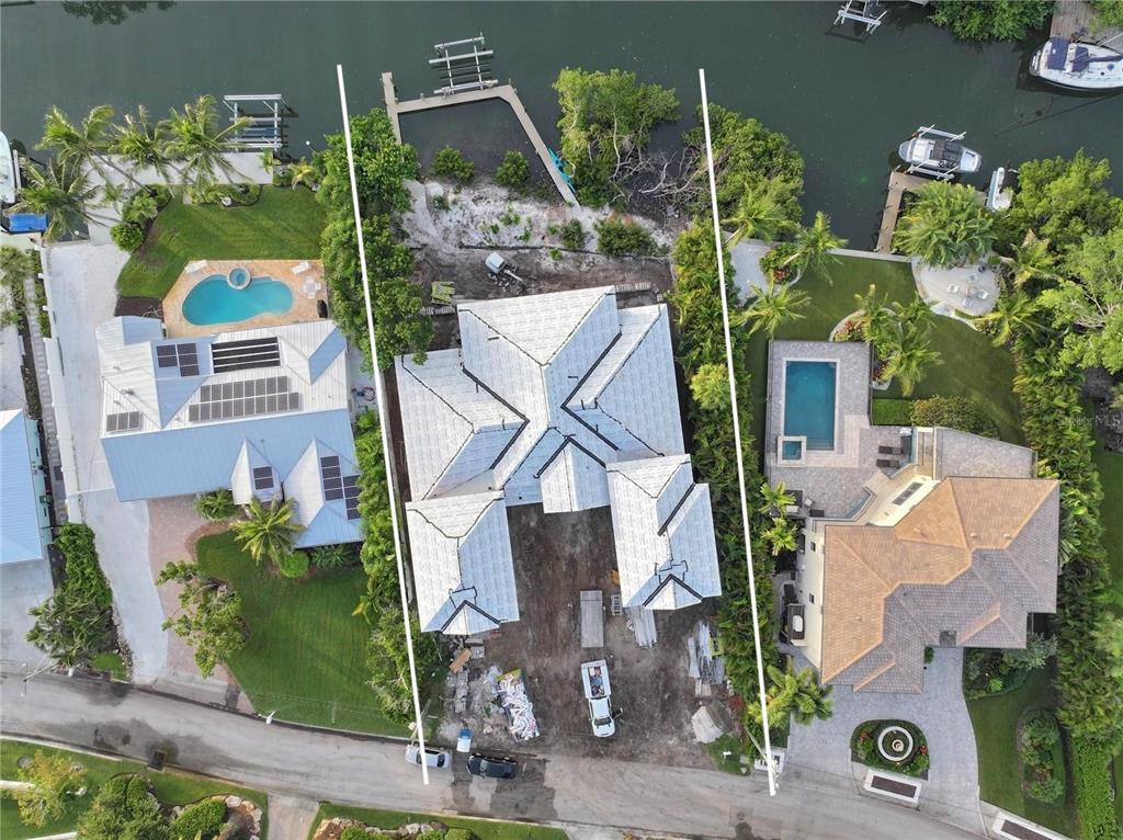 An aerial view shows a house under construction on a waterfront lot between two homes — 3441 GULFMEAD DRIVE, SARASOTA, FL