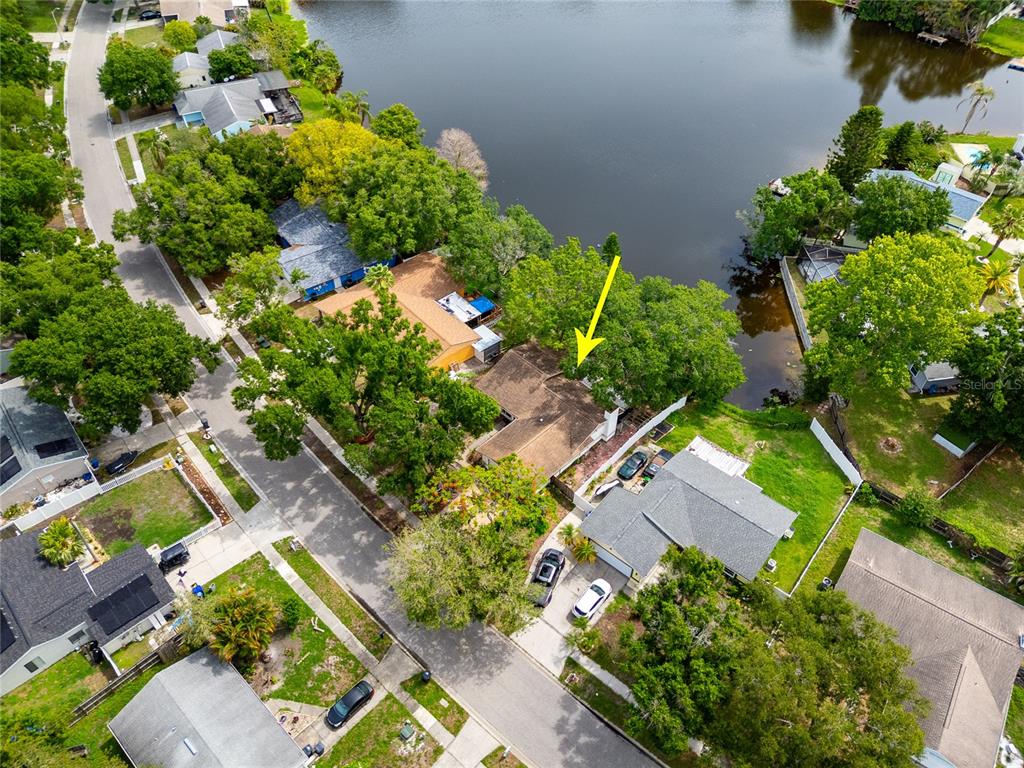 An aerial view shows a residential house with a brown roof near a lake — 627 TIMBER BAY CIRCLE W, OLDSMAR, FL
