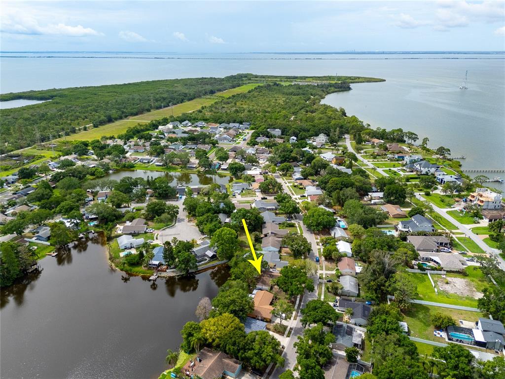 An aerial view shows a residential neighborhood with a yellow arrow pointing to a house — 627 TIMBER BAY CIRCLE W, OLDSMAR, FL