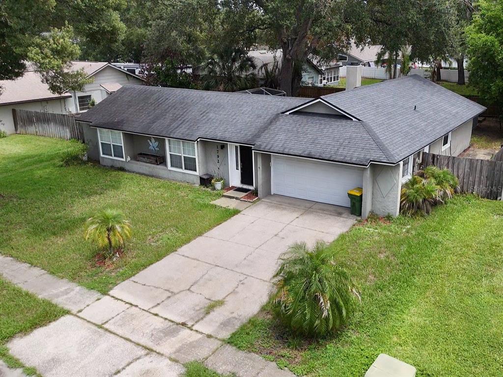 An aerial view of a single-story house with a gray shingled roof and concrete driveway — 1792 PAM CIRCLE, ORLANDO, FL