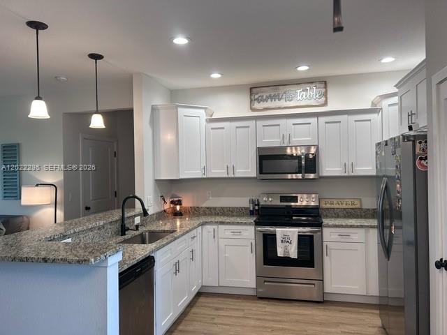 A kitchen features white cabinets, stainless steel appliances, and granite countertops — 109 Vale Cr, Sebring FL 33876, SEBRING, FL