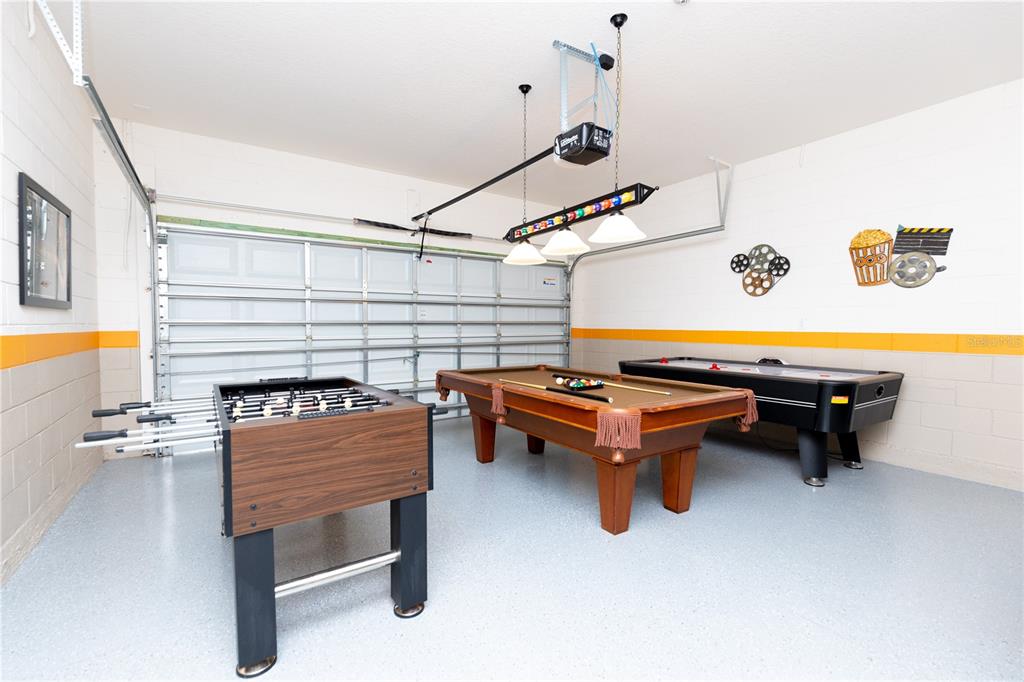 A garage converted into a game room with a foosball table, pool table, and air hockey — 2784 ROCCELLA COURT, KISSIMMEE, FL