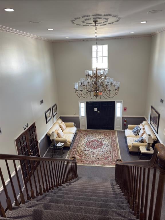 A high-angle view of a carpeted staircase leading to a lobby with two sofas — 949 TAMIAMI TRAIL UNIT 102, PORT CHARLOTTE, FL